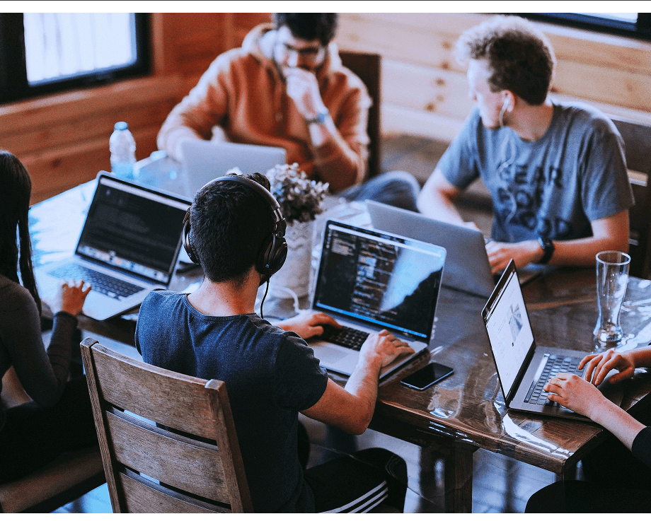 Team of professionals working together at a table with laptops