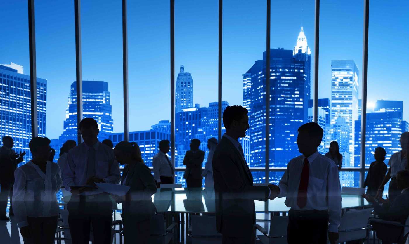 Senior teams working against a city skyline at night